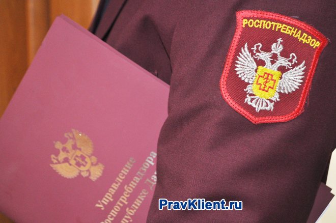 Rospotrebnadzor employee holds a folder with documents in his hand